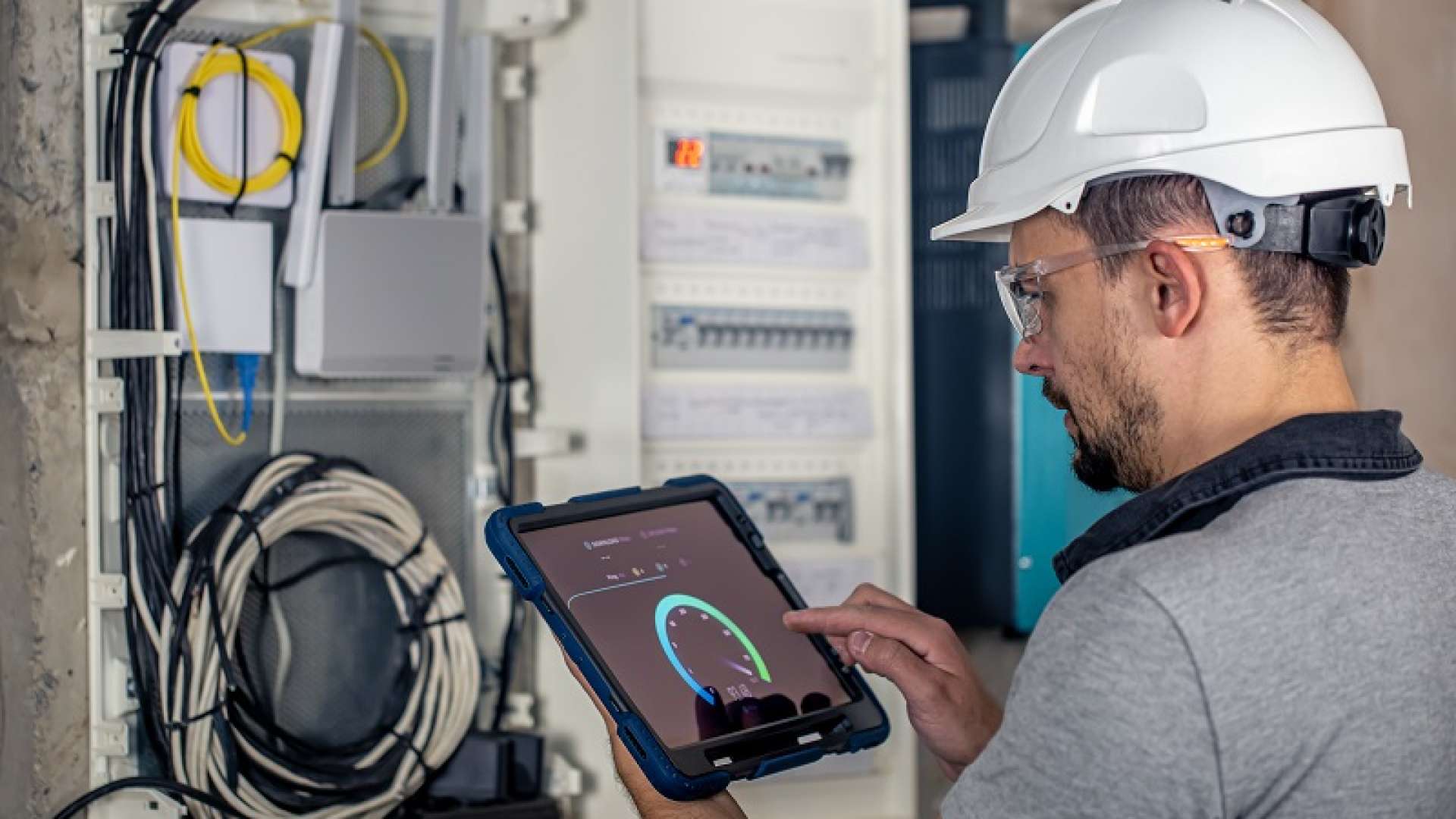 Man, an electrical technician working in a switchboard with fuses. Installation and connection of electrical equipment.